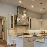 custom zinc range hood with polished metal straps in a kitchen