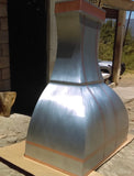 hadcrafted range hood from zinc metal decorated with copper straps