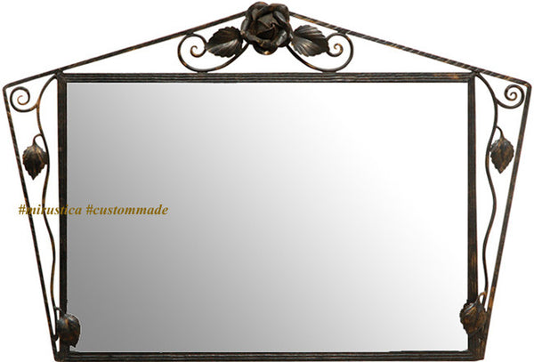 Rose Accent Wrought Iron Wall Mirror with a rectangular reflective surface framed by dark iron scrollwork, featuring a sculpted rose and leaf accents at the top and sides, combining floral artistry with handcrafted metal design.